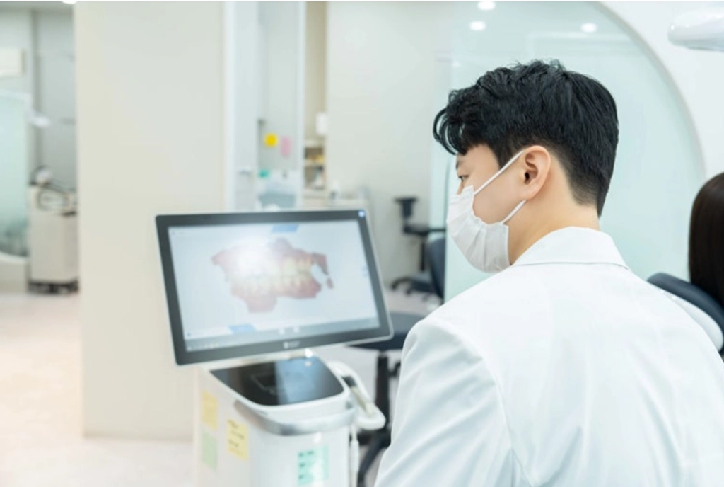 모니터로 정밀 진단 데이터를 분석하며 수면임플란트 수술 계획을 세우고 있는 블랑쉬치과 김태형 원장의 모습