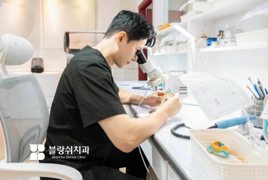 블랑쉬치과 의료진이 현미경으로 정밀 라미네이트 작업 중